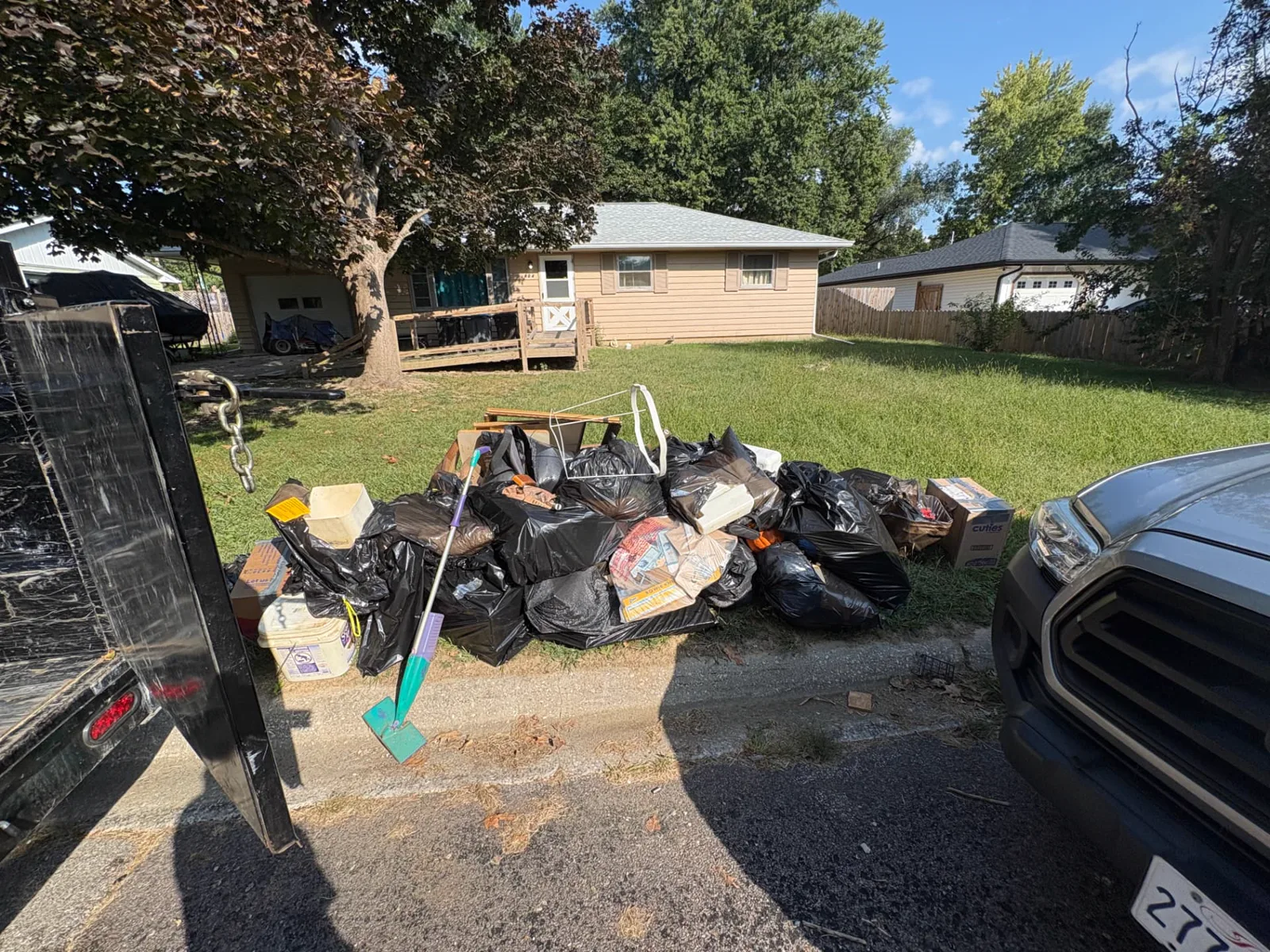 Bagged household items and debris at a residential curb before TrashDash pickup